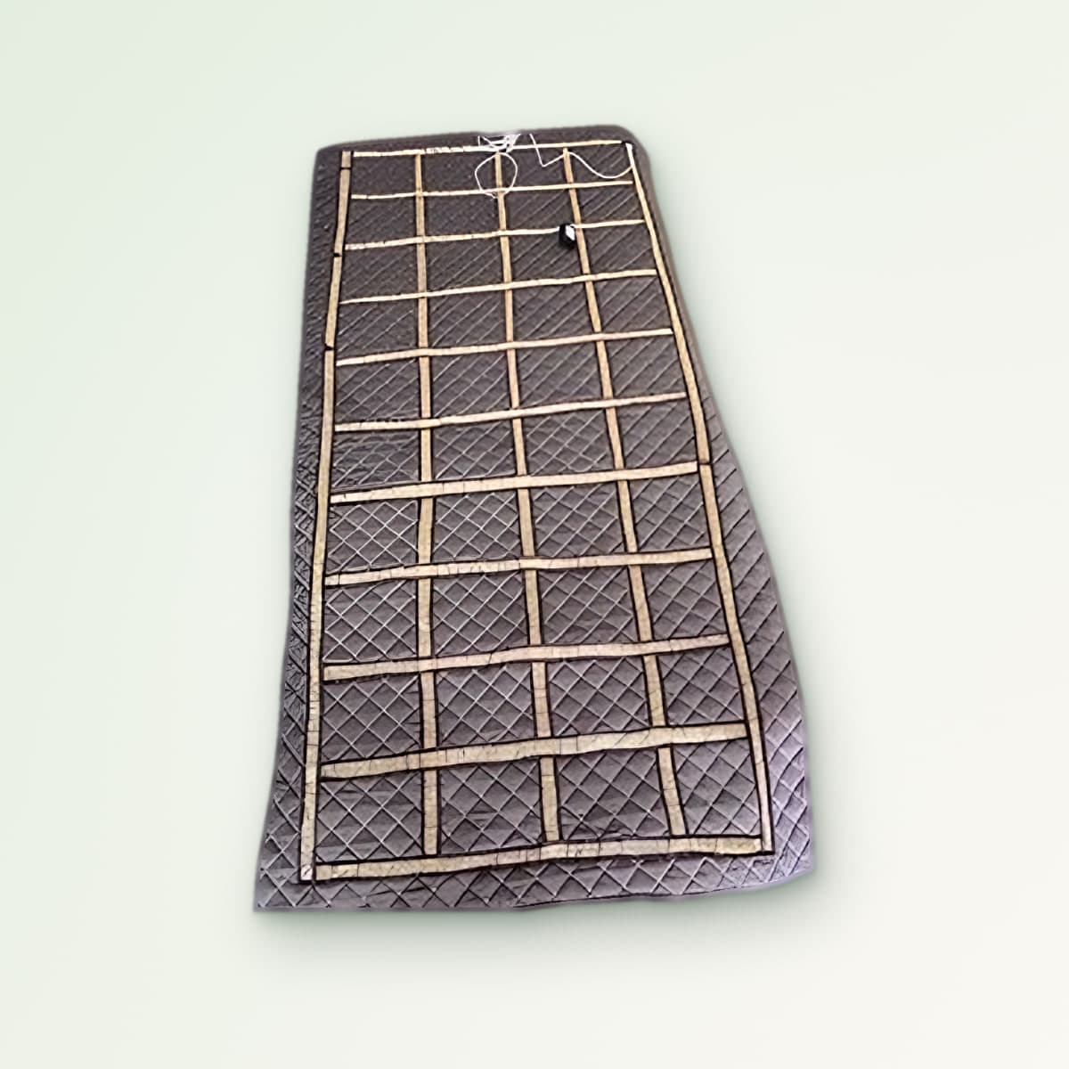 Zero Volt Bedsheet: quilted earthing mat with a brass-coloured conductive grid and earthing cord, laid flat